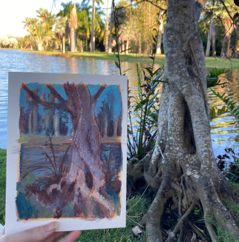A plein-air painting of a tree, held up near the tree.